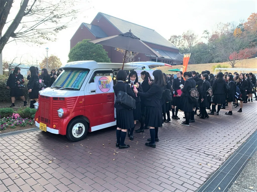 学生がイベントでキッチンカーに行列を作っている