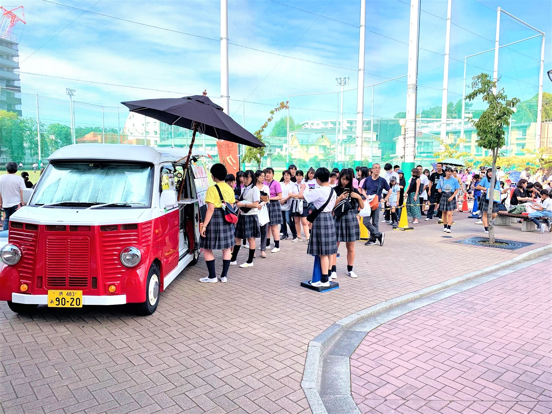 文化祭で学生がクレープを買うためにキッチンカーに並んでいる