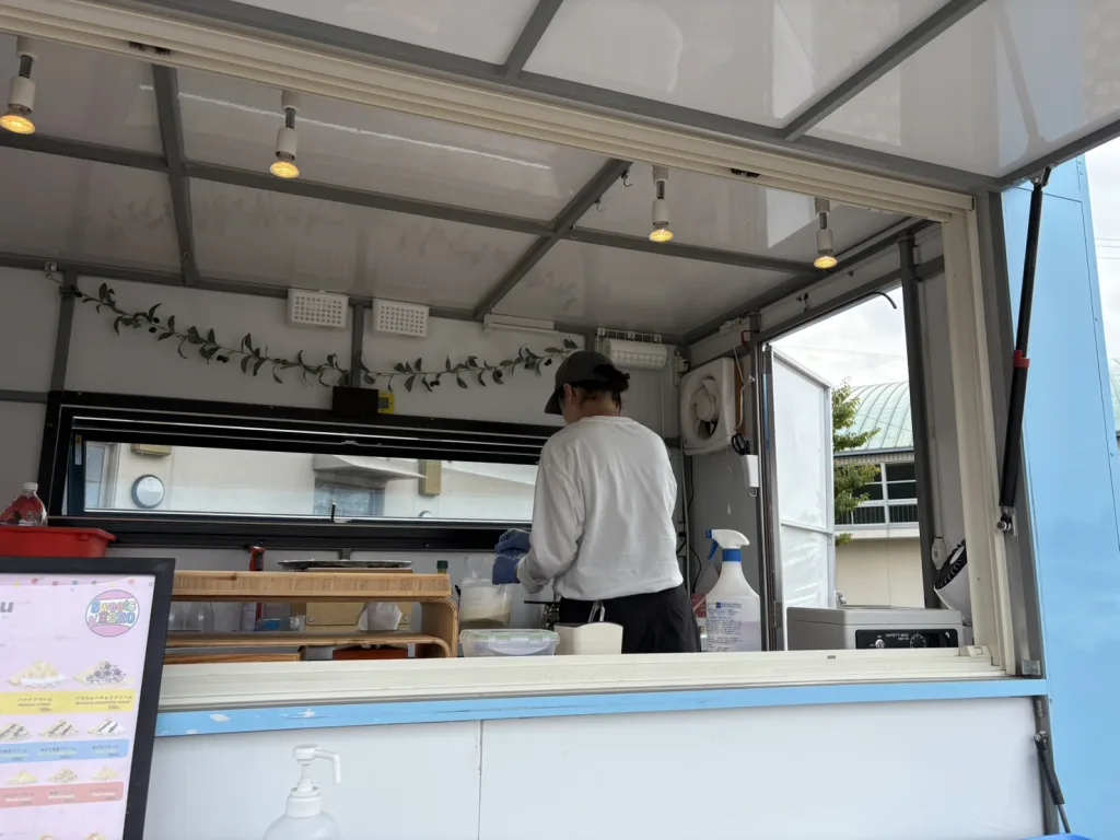 キッチンカーの中でクレープ生地焼き中