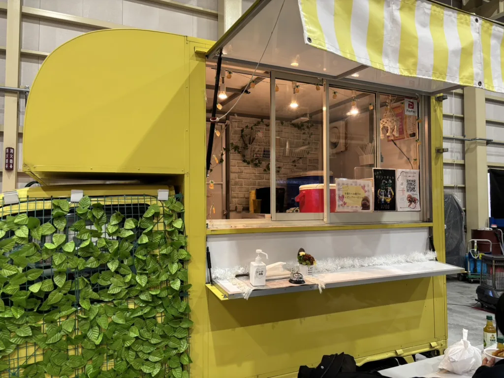 マイティミズタニの忘年会でクレープを提供する黄色のキッチンカー